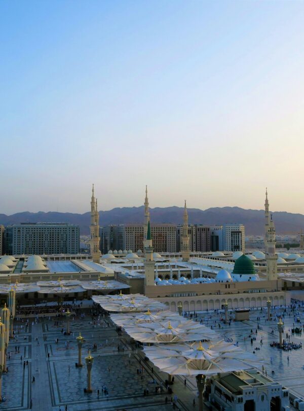 Aerial view of Al-Masjid an-Nabawi with minarets at sunset in Medina, Saudi Arabia.