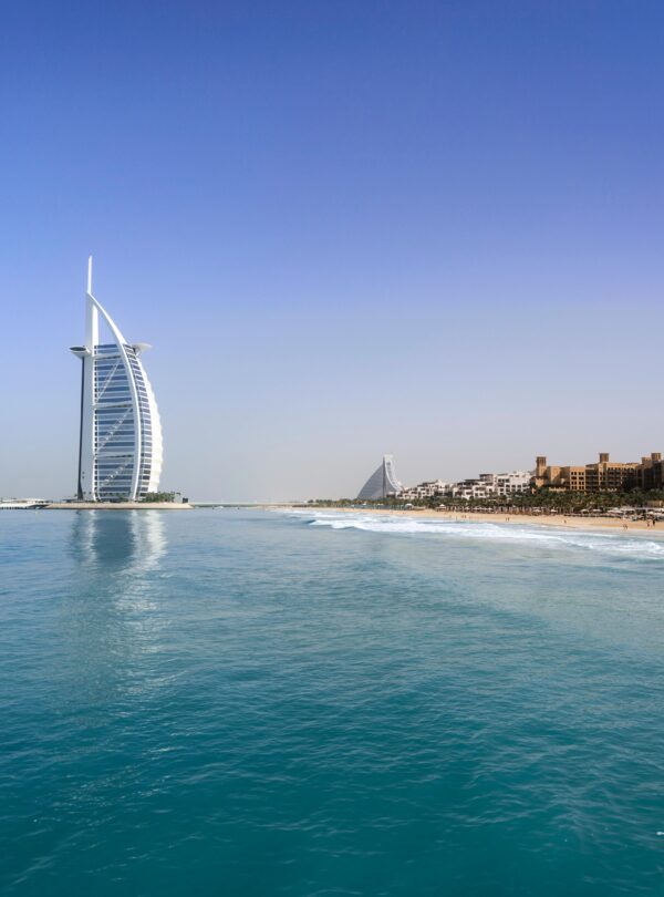Iconic Burj Al Arab overlooking the pristine Dubai beach, perfect for travel and leisure.
